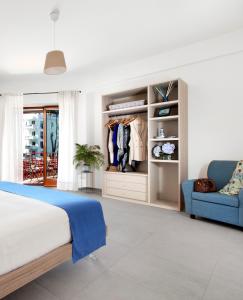 1 dormitorio con 1 cama y 1 sofá azul en Torna a Surriento Suites, en Sorrento