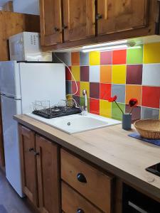 a kitchen with a sink and a colorful tile wall at les 3 marmottes - Les Arolles in Bourg-Saint-Maurice