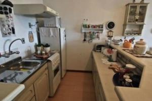 Una cocina con fregadero, estufa y refrigerador. en Apartamento charmoso com piscina, en Gramado