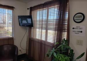 uma sala de estar com televisão e janela em Executive Inn Woodward em Woodward