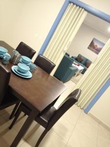 Un comedor con mesa y sillas de madera. en Nuzul Altoot Apartments نزل التوت, en Riad