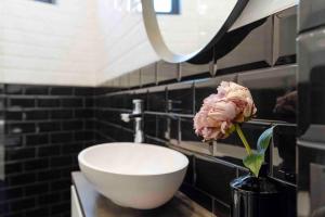 a bathroom with a sink and a flower in a vase at Beautiful Studio - Top Location - Netflix in Bucharest +36 photos