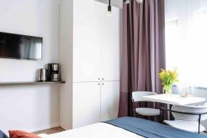 a bedroom with a bed and a table with chairs at Beautiful Studio - Top Location - Netflix in Bucharest