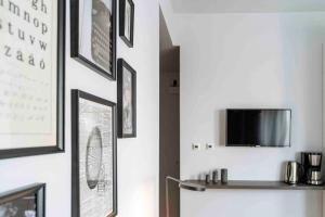 a room with a wall with pictures and a tv at Beautiful Studio - Top Location - Netflix in Bucharest