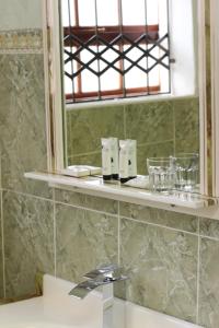 ein Badezimmer mit Spiegel und Waschbecken in der Unterkunft Guesthouse@Mbalistar in Queenstown