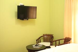 ein Zimmer mit zwei Stühlen und einem Tisch und einem Fernseher in der Unterkunft Guesthouse@Mbalistar in Queenstown