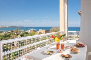 Una mesa con comida en un balcón con vistas al océano en Iliostasi Beach Apartments, en Hersonissos