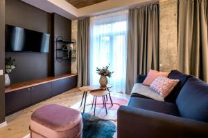 a living room with a blue couch and a table at Marvellous Design 2Br Old Town in Bucharest