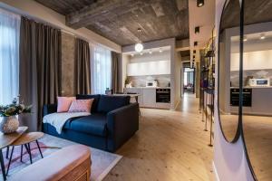 a living room with a blue couch and a kitchen at Marvellous Design 2Br Old Town in Bucharest
