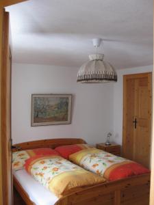 een slaapkamer met een bed en een kroonluchter bij Casa Zupada/Wegmüller in Lenzerheide