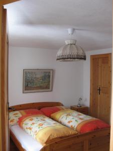 a bedroom with a bed and a chandelier at Casa Zupada/Wegmüller in Lenzerheide