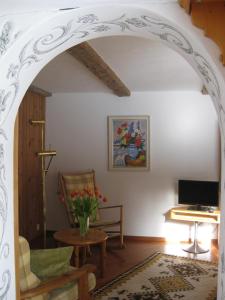 een boog in een woonkamer met een stoel en een tafel bij Casa Zupada/Wegmüller in Lenzerheide