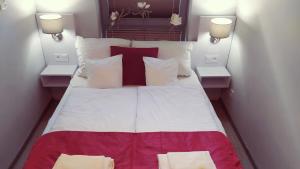 a bedroom with a large bed with red and white pillows at Apartament Elvira, Grunwaldzka 12C in Pobierowo