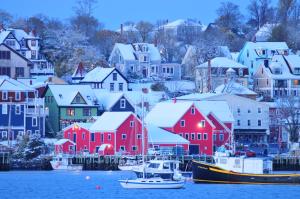 a town with red houses and boats in the water at Smugglers Cove Inn in Lunenburg