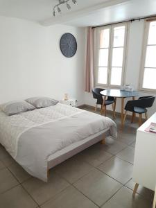 a bedroom with a bed and a table and chairs at Charmant studio au coeur de St Leu hyper centre in Amiens