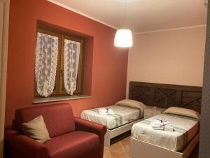 Pokój z 2 łóżkami, krzesłem i kanapą w obiekcie AGRITURISMO Da Baffone w mieście Santo Stefano del Sole
