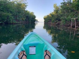 una persona con los pies en un kayak en un río en Coconut Cay Resort en Marathon