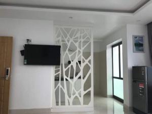 a living room with a tv on a wall at Cosy Star Apartment and Motel in Hai Phong