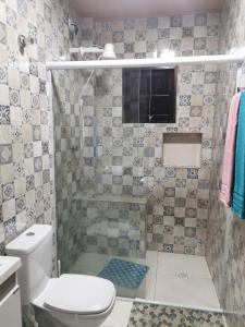 a small bathroom with a toilet and a shower at Recanto Dumar in Peruíbe