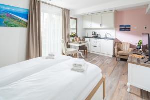 um quarto com uma cama grande e uma cozinha em Heimathafen Juist em Juist