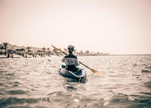 a person in a kayak in the water at The Cove Rotana Resort - Ras Al Khaimah in Ras al Khaimah