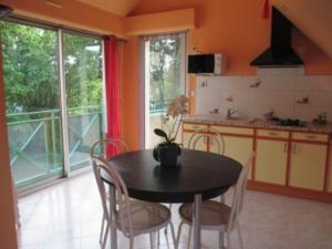 a kitchen with a black table and chairs in a room at La Petite Londe in Biéville-Beuville