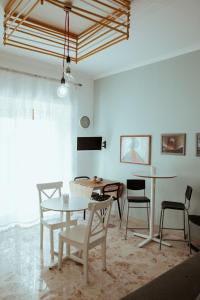 Un comedor con mesas y sillas blancas. en SoStanza - Rooms in Catania, en Catania