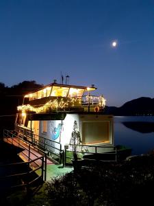 un barco con luces en el agua por la noche en Hausboot MS Donautal en Neuhaus