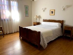 a bedroom with a large bed and a wooden floor at Location d'une maison typique du Pays Basque in Caro