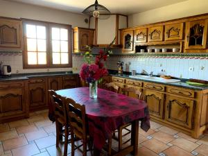 a kitchen with a table with a vase of flowers on it at Location d'une maison typique du Pays Basque in Caro +4 photos