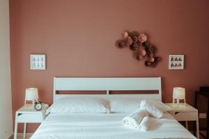 a bedroom with a white bed with two night stands at SoStanza - Rooms in Catania in Catania
