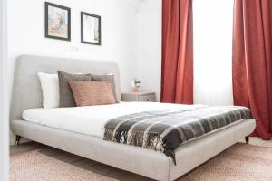 1 dormitorio con 1 cama grande y cortinas rojas en Sunny 2BR Flat - Old Town View, en Bucarest