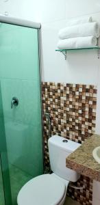 ein Bad mit einem WC, einem Waschbecken und Handtüchern in der Unterkunft Infinity Hotel in Goiânia