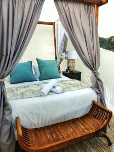 a bedroom with a bed with blue pillows at The Bubble Valley in Piet Retief