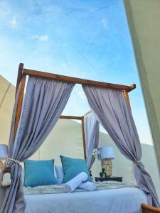 1 dormitorio con 1 cama con almohadas azules en The Bubble Valley, en Piet Retief