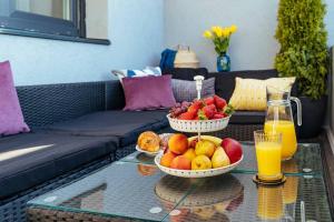 two bowls of fruit on a glass table with juice at Sunset Terrace in the Old Town in Bucharest