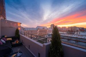 a balcony with a view of a city at sunset at Sunset Terrace in the Old Town in Bucharest