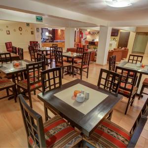 a restaurant with wooden tables and chairs and tablesktop at Tampu Hotel in Cusco