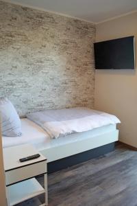 a bedroom with a bed and a nightstand next to it at City Pension Stadtlohn in Stadtlohn
