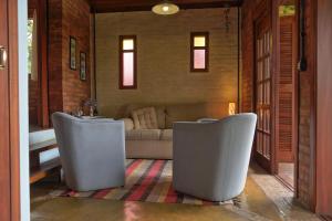 sala de estar con 2 sillas y sofá en Pousada Candeias, en Cunha