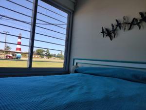 a bedroom with a bed and a window with a lighthouse at Luz de faro in Mar del Plata
