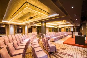 a banquet hall with white chairs and a podium at La Perle International Hotel - Free shuttle between hotel and Exhibition Center during Canton Fair in Guangzhou