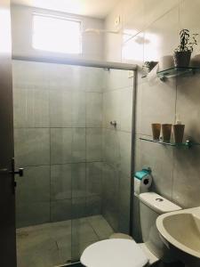 a bathroom with a shower with a toilet and a sink at Aconchego na Capital do Forró - Térreo in Caruaru