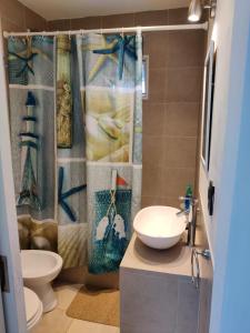 a bathroom with a sink and a toilet and a shower curtain at Luz de faro in Mar del Plata