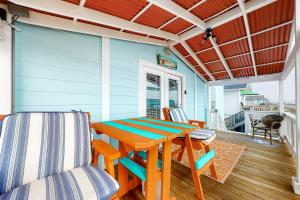 a blue house with a wooden table and chairs on a porch at O' What A View in Gilchrist