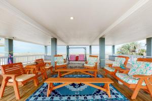 a porch with wooden tables and chairs and the ocean at O' What A View in Gilchrist