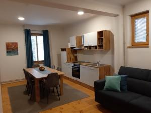 a living room with a table and a kitchen at Triglav Apartment House in Kranj