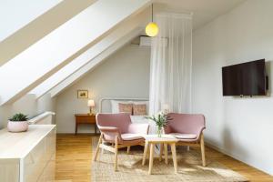 een woonkamer met 2 stoelen en een tafel bij Vivando - Sunny Studio F + Parking in Boekarest
