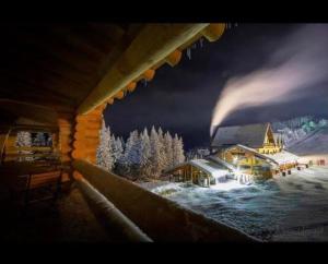 a picture of a lodge in the snow at night at Pensiunea Rancaski in Ranca