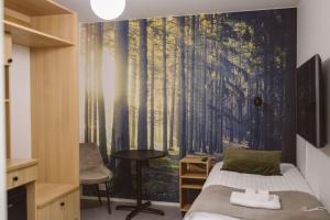 a bedroom with a wall mural of a forest at Villa Veromäki in Vantaa